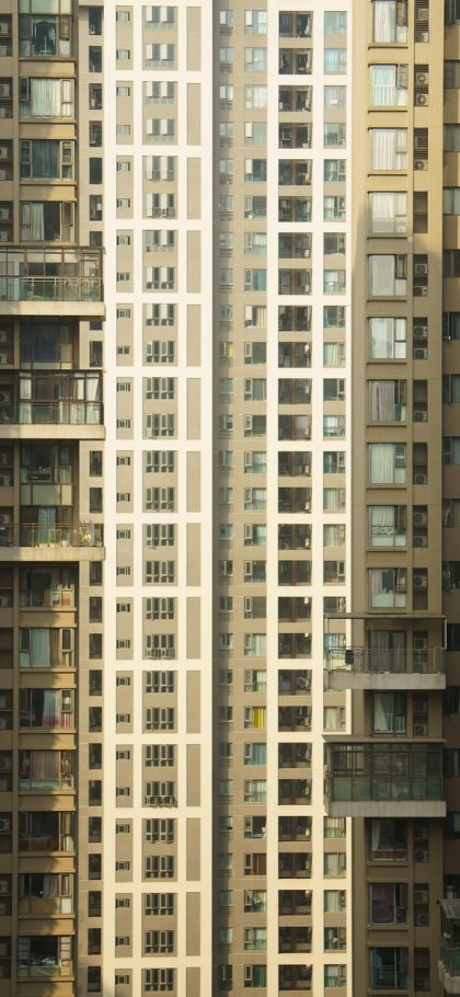 大a App 行情总览界面竖屏截图，深紫色卡片上排列着指数数值与红绿涨跌条，窗外夜色映在手机屏幕上